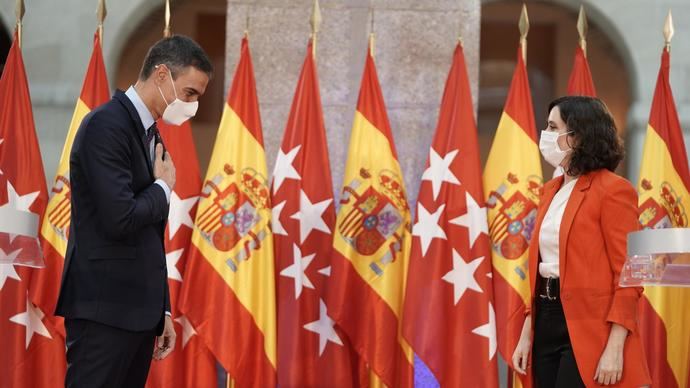 Pedro Sánchez e Isabel Díaz Ayuso entre banderas.