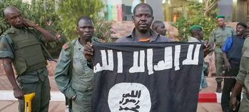 Oficiales de las fuerzas de seguridad de Mali muestran una bandera yihadista en Bamako.