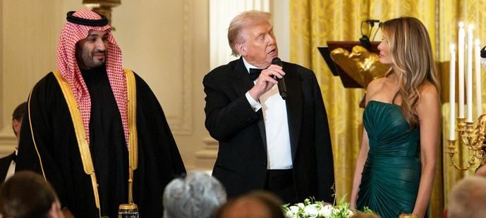 Donald Trump habla con su esposa Melania, en presencia del príncipe saudí Muhamad ben Salman.