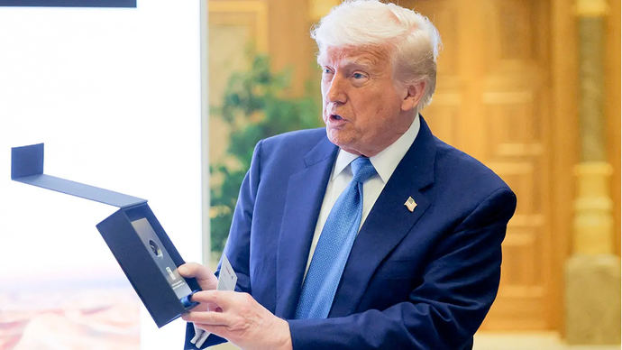 Donald Trump sostiene una muestra de petróleo en un foro empresarial en Qasr Al Watan durante la última parada de su visita al Golfo, en Abu Dabi 
